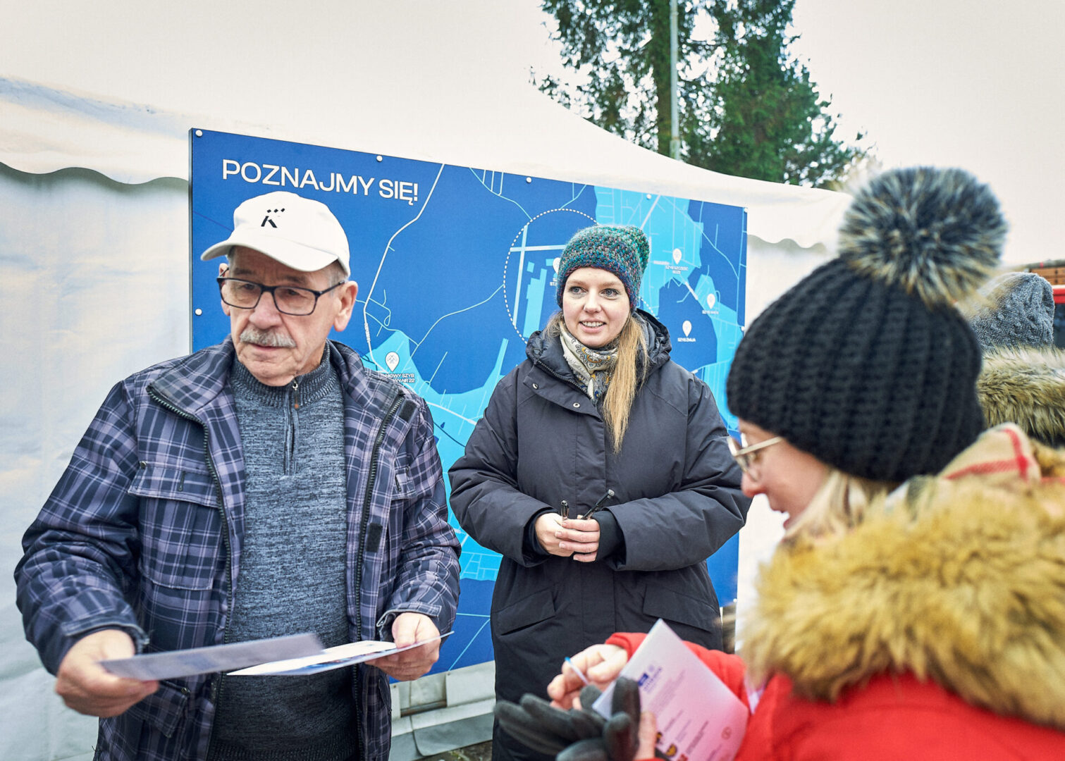 Uczestnicy wycieczki stoją przy mapie Rept z napisem "Poznajmy się!". 
