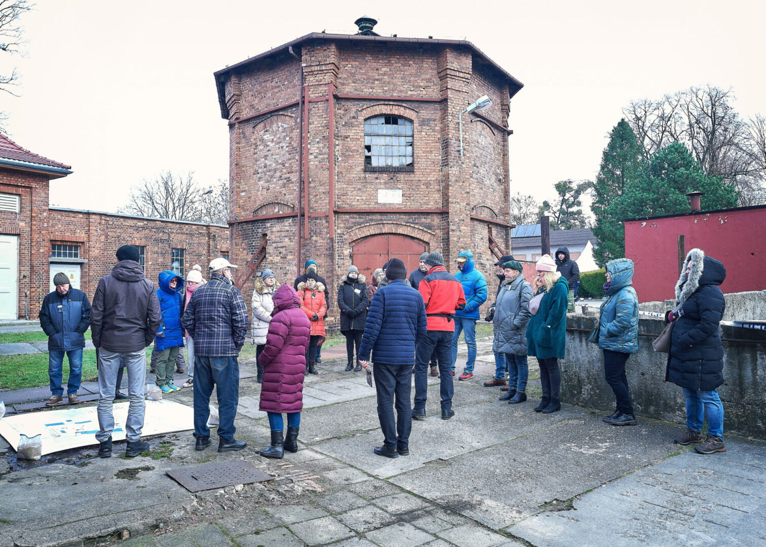 Uczestnicy wycieczki wraz z przewodnikiem omawiają stare mapy terenu.