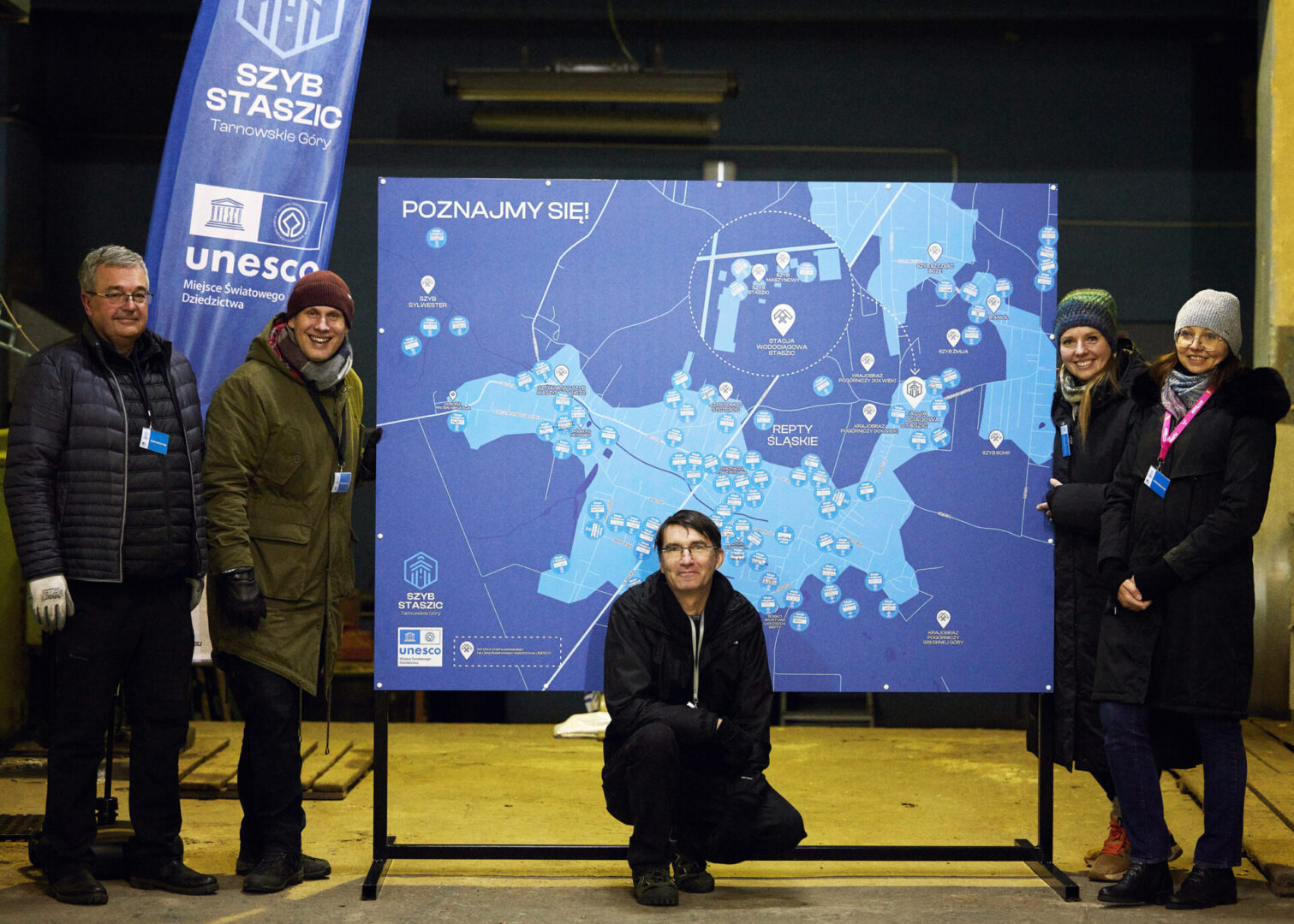 Pracownicy instytucji kultury "Szyb Staszic w Tarnowskich Górach" stoją uśmiechnięci przy wypełnionej naklejkami mapie Rept.
