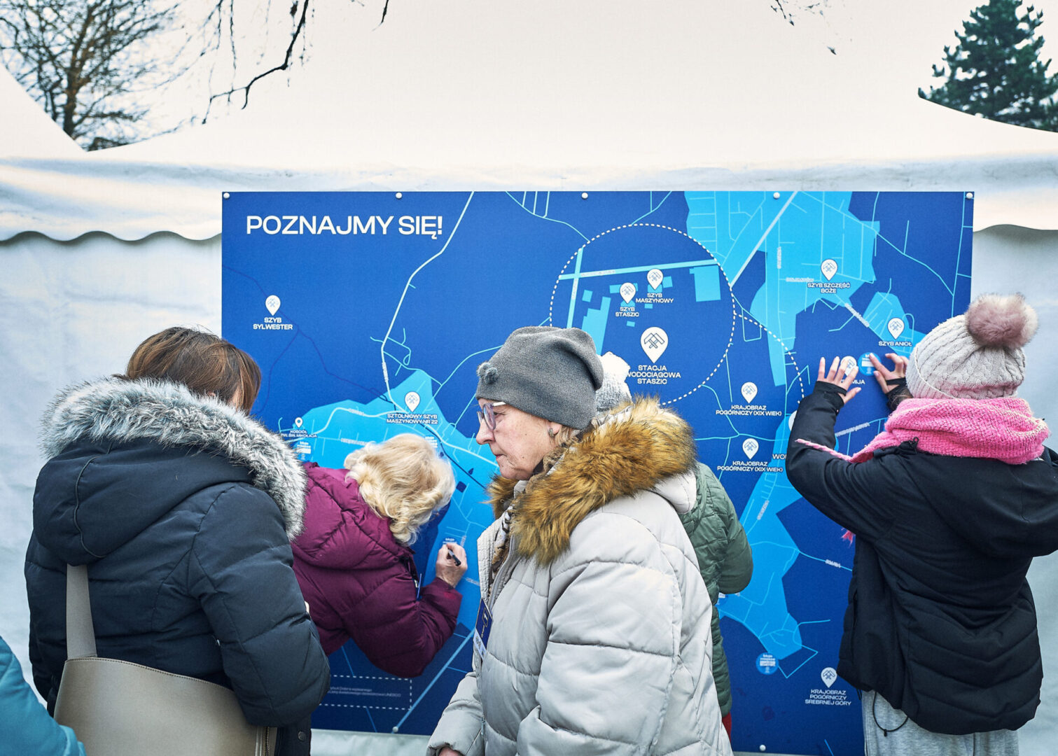 Grupa mieszkańców Rept przykleja naklejki na mapę Rept.