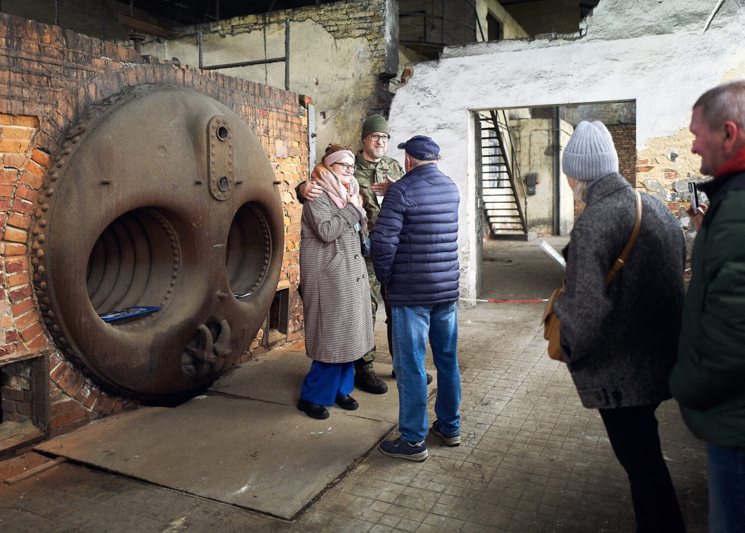 Uczestnicy wycieczki stoją przy starym piecu.
