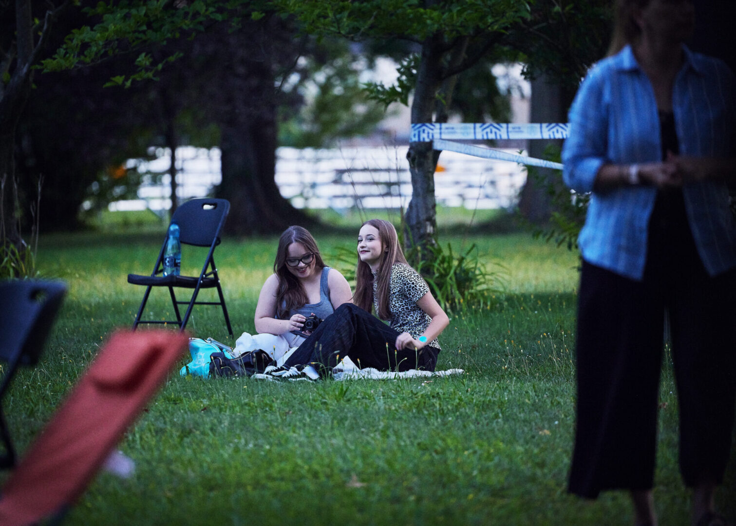 Widzowie kina plenerowego siedzą na trawie na terenie Stacji Wodociągowej Staszic