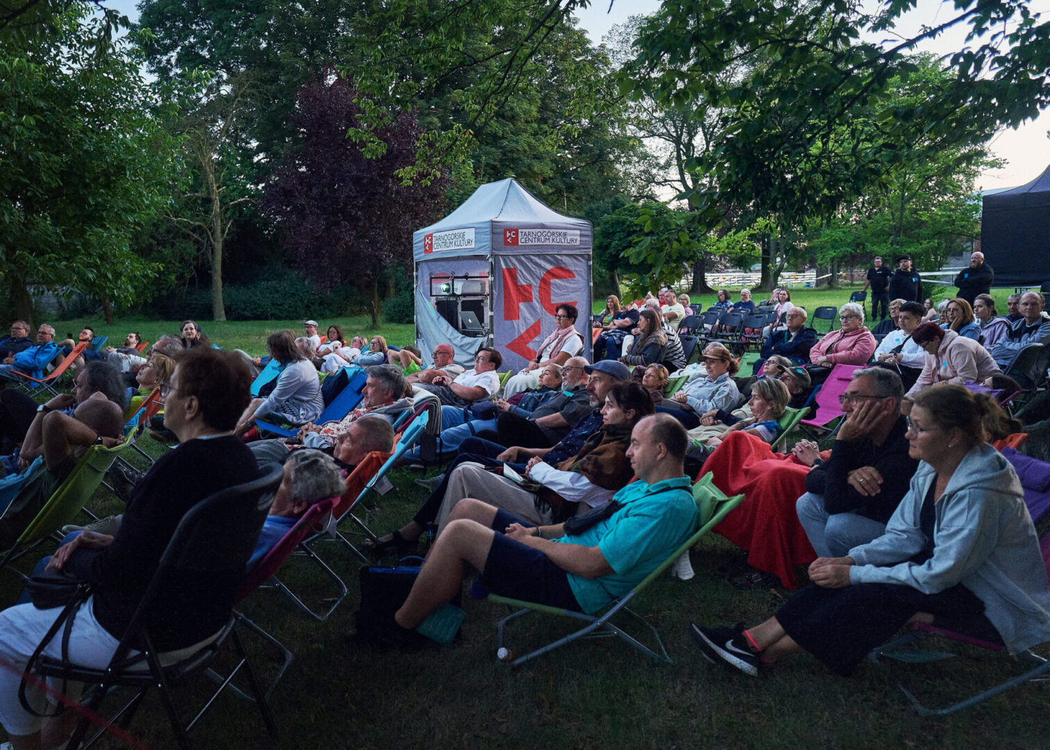 Widzowie kina plenerowego siedzą na leżakach na terenie Stacji Wodociągowej Staszic